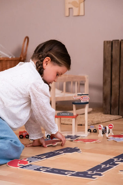 Auto's op de Weg – Egmont Toys : enfant jouant avec le circuit de voitures en bois.