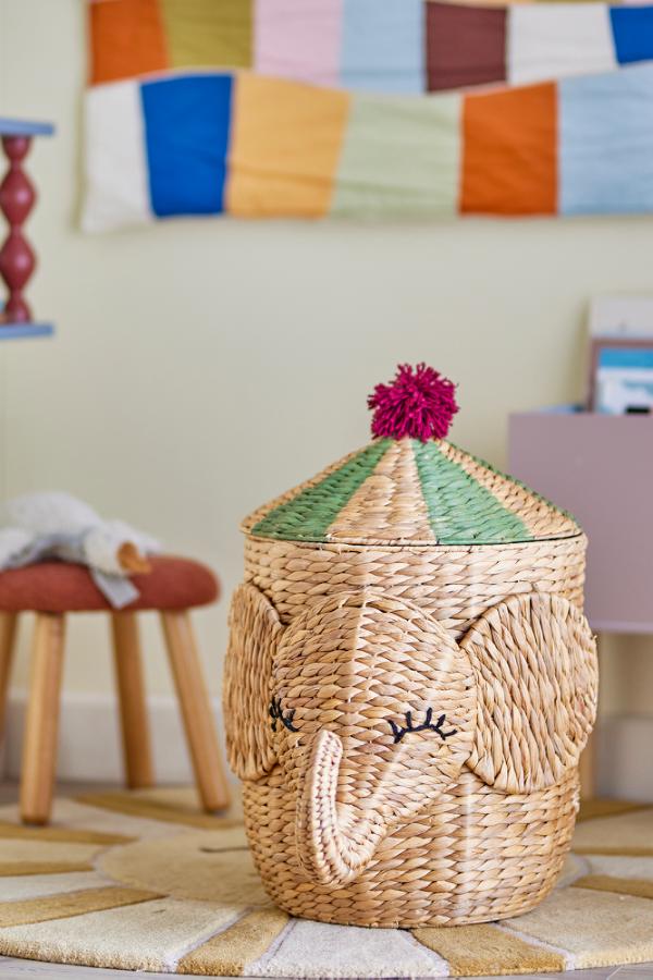 Bobo Basket Nature – Panier de rangement éléphant avec couvercle – Bloomingville MINI : panier avec tête d'éléphant à côté d'un lit d'enfant.