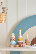 Celebrate Activity Toy – Bloomingville MINI: stapelspeelgoed op een plank in de kinderkamer.