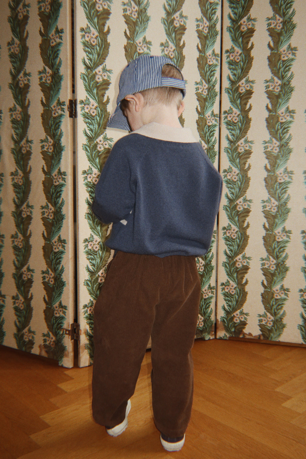 Wollen polo Basi – Dark Blue Stripe – Konges Sløjd: kind met blauwe polo en bruine broek, van achteren.
