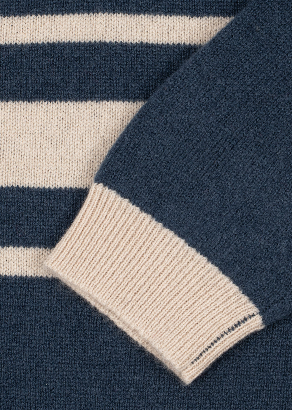 Wollen polo Basi – Dark Blue Stripe – Konges Sløjd: detail van lichte strepen en het mouwboord van de blauwe polo.