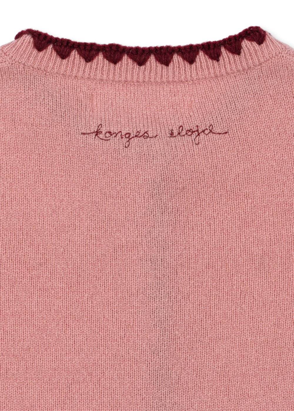 Wollen vest Collette – Pale Blush – Konges Sløjd: detail van de geborduurde merknaam en halsrand achterop het vest.